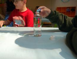 Bottle with oil and water on a table.